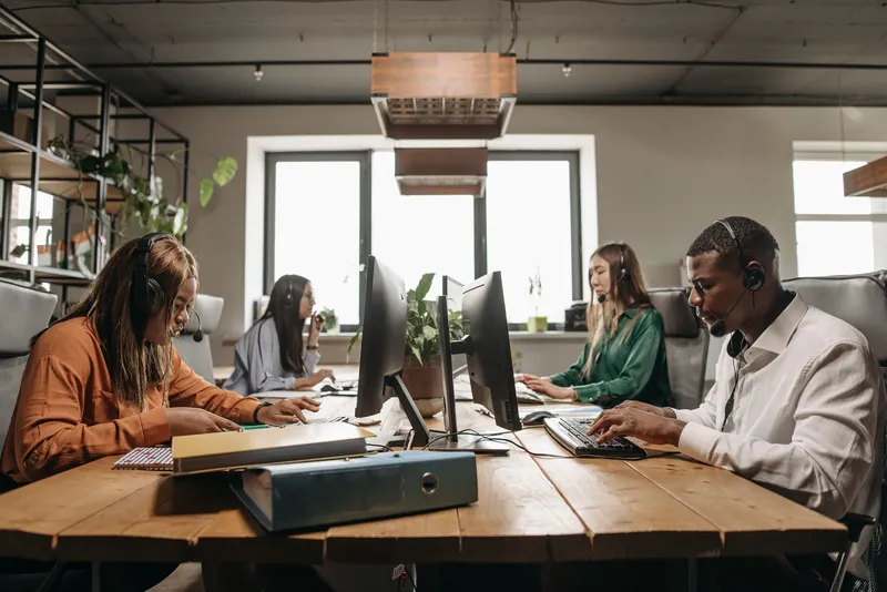 A team of employees with headsets collaborating in an open office