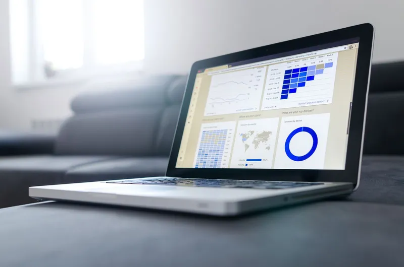 A laptop showing data analytics charts in a bright room