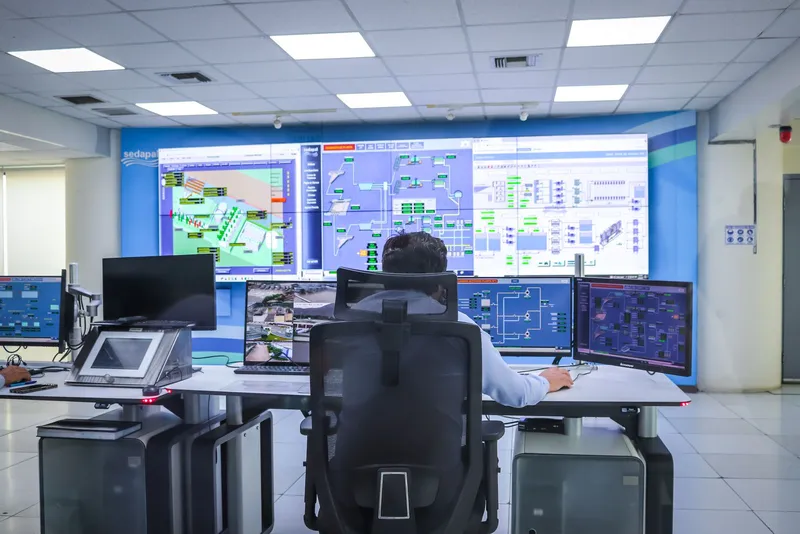 An operator in a control room in front of several monitoring screens