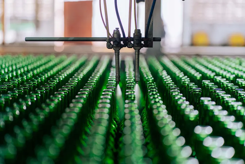 Glass bottles moving along an automated factory line