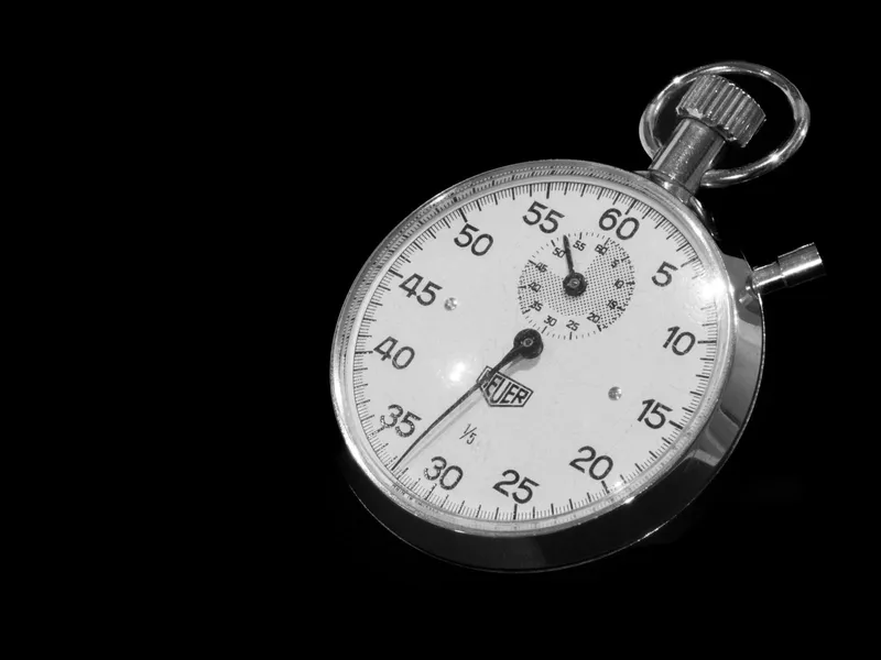 A vintage mechanical stopwatch against a dark background