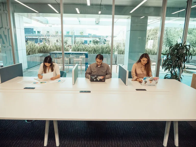 Three professionals working together with laptops and documents