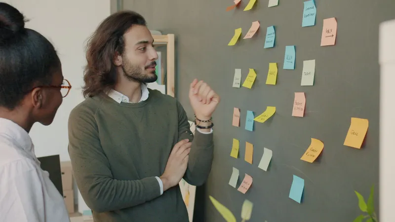Colleagues brainstorming with colourful sticky notes on a wall